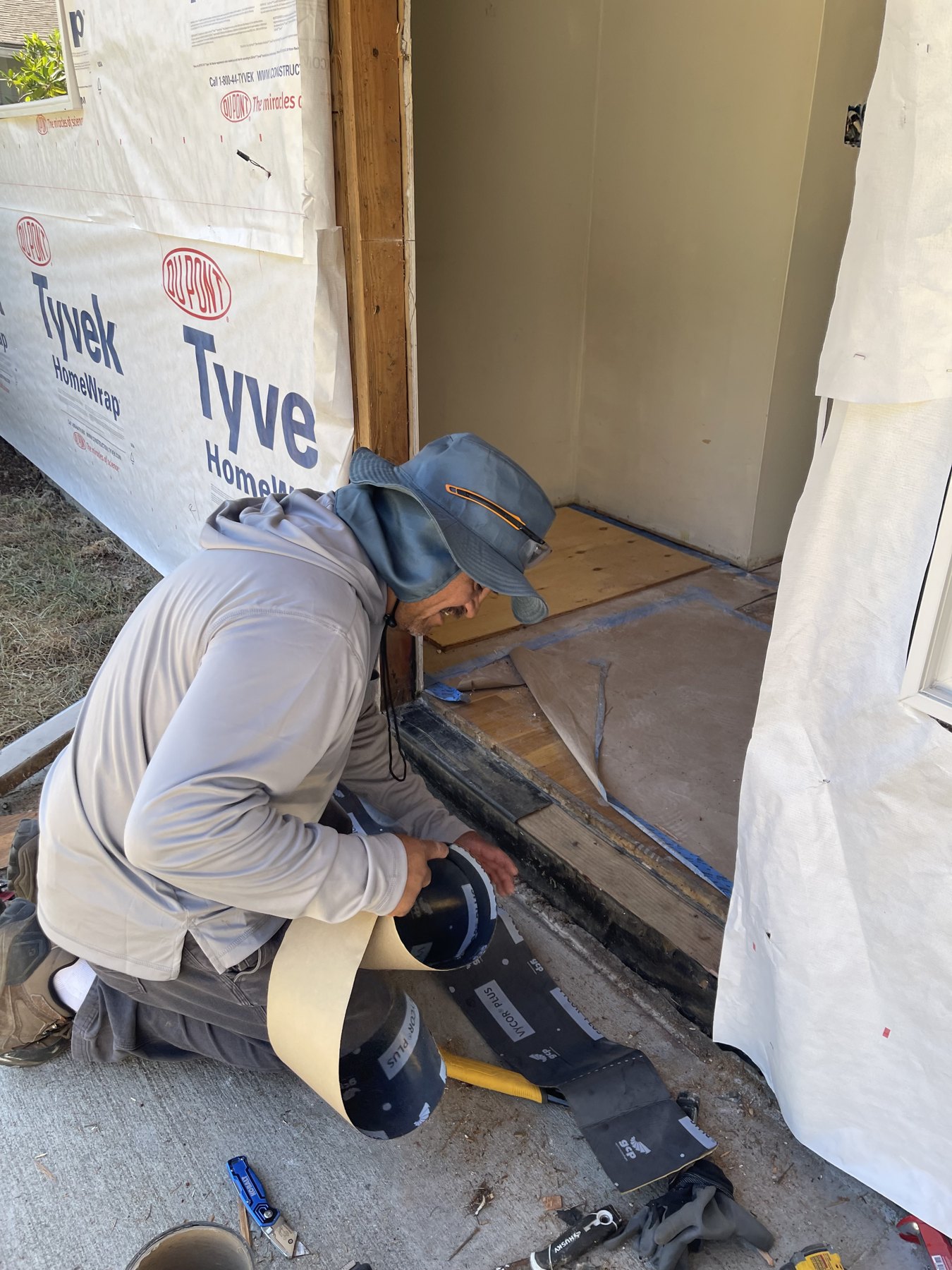 Team member carefully masking a doorway before painting